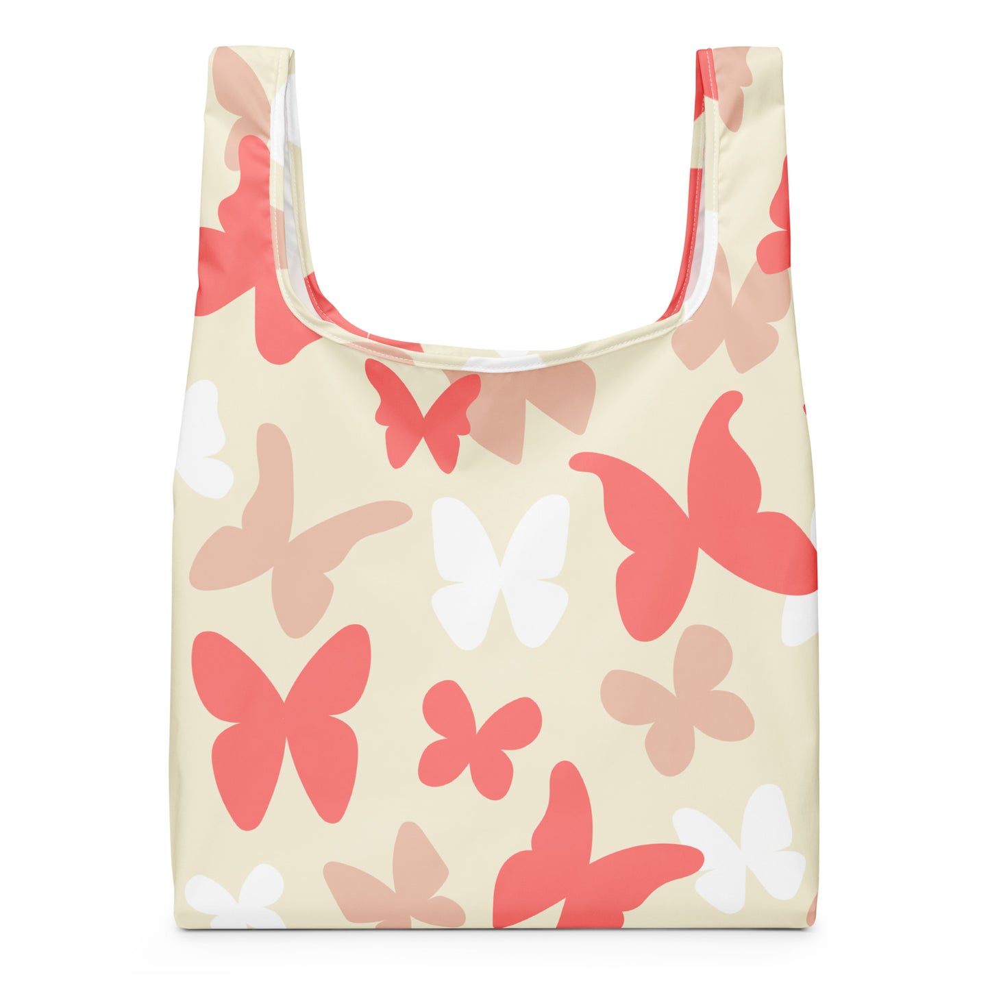 A reusable tote bag with a cream background and a pattern of stylized butterflies in coral red, light pink, and white.