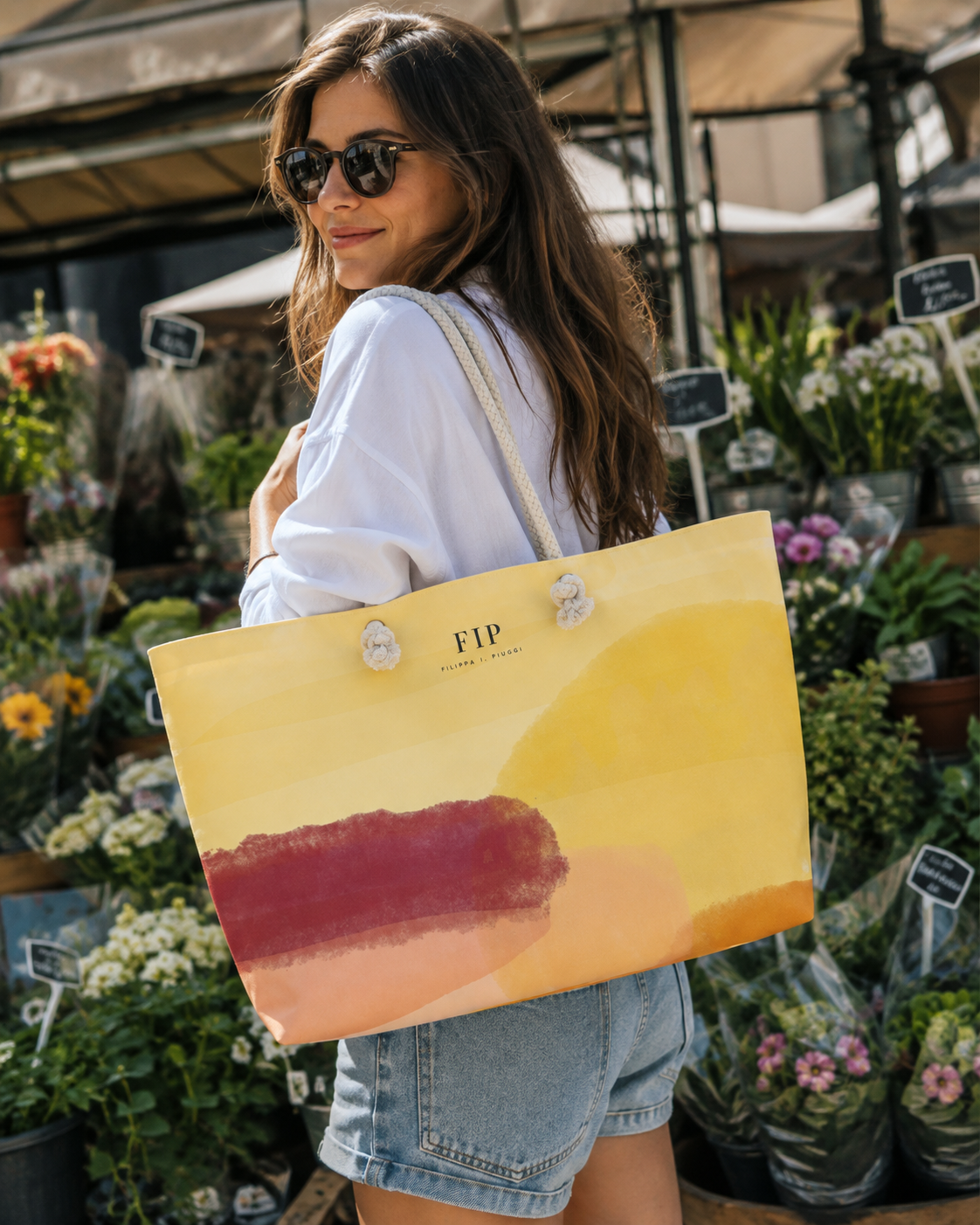 large tote bag with a yellow and orange abstract sunset design and a dark red brushstroke.