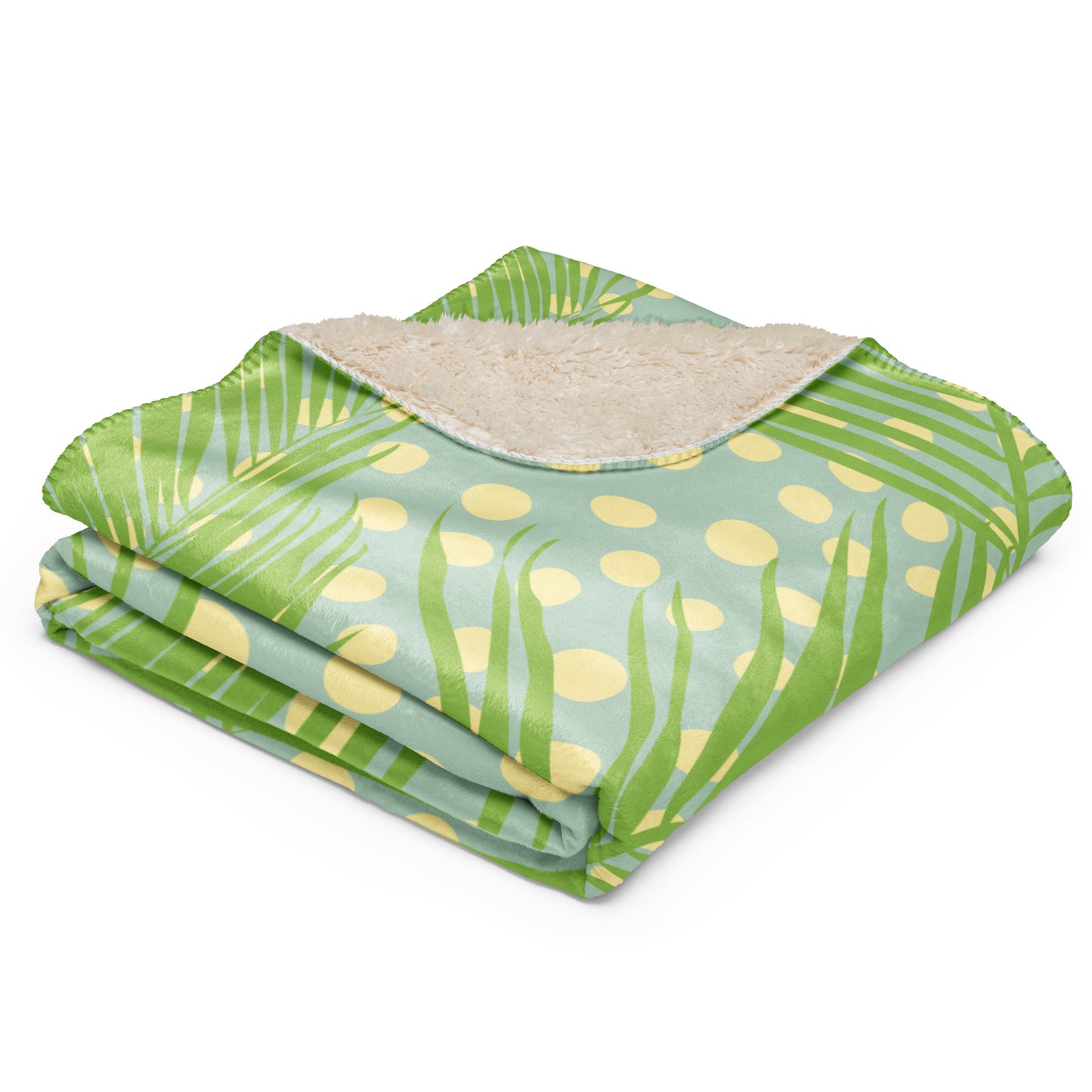Green tropical palm leaf and polka dot pattern on one side, with a soft beige sherpa lining.