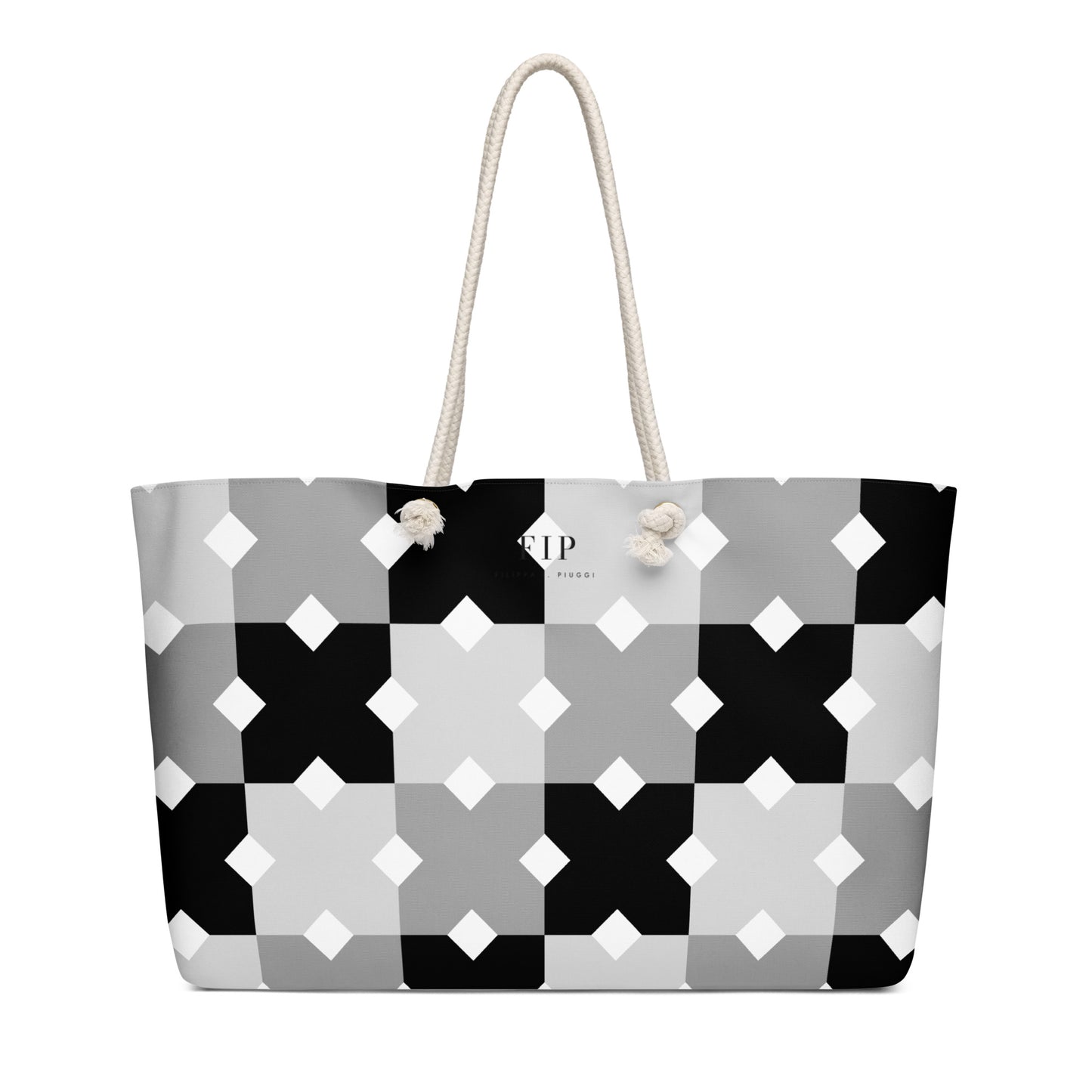 A tote bag with a geometric black, gray, and white pattern, featuring cream-colored rope handles