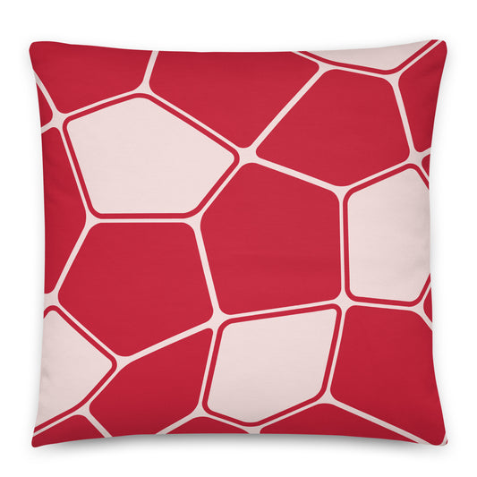 A square throw pillow featuring a modern geometric pattern of red and pale pink irregular polygon shapes outlined in white.