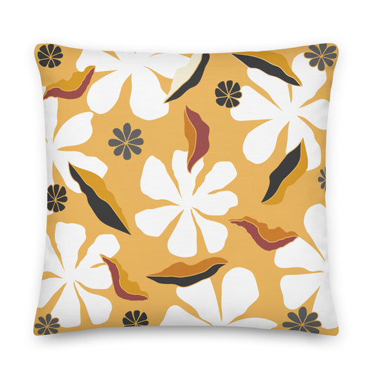 A square throw pillow featuring a retro floral pattern with large white flowers, mustard yellow background, and abstract black and rust-brown leaf shapes.