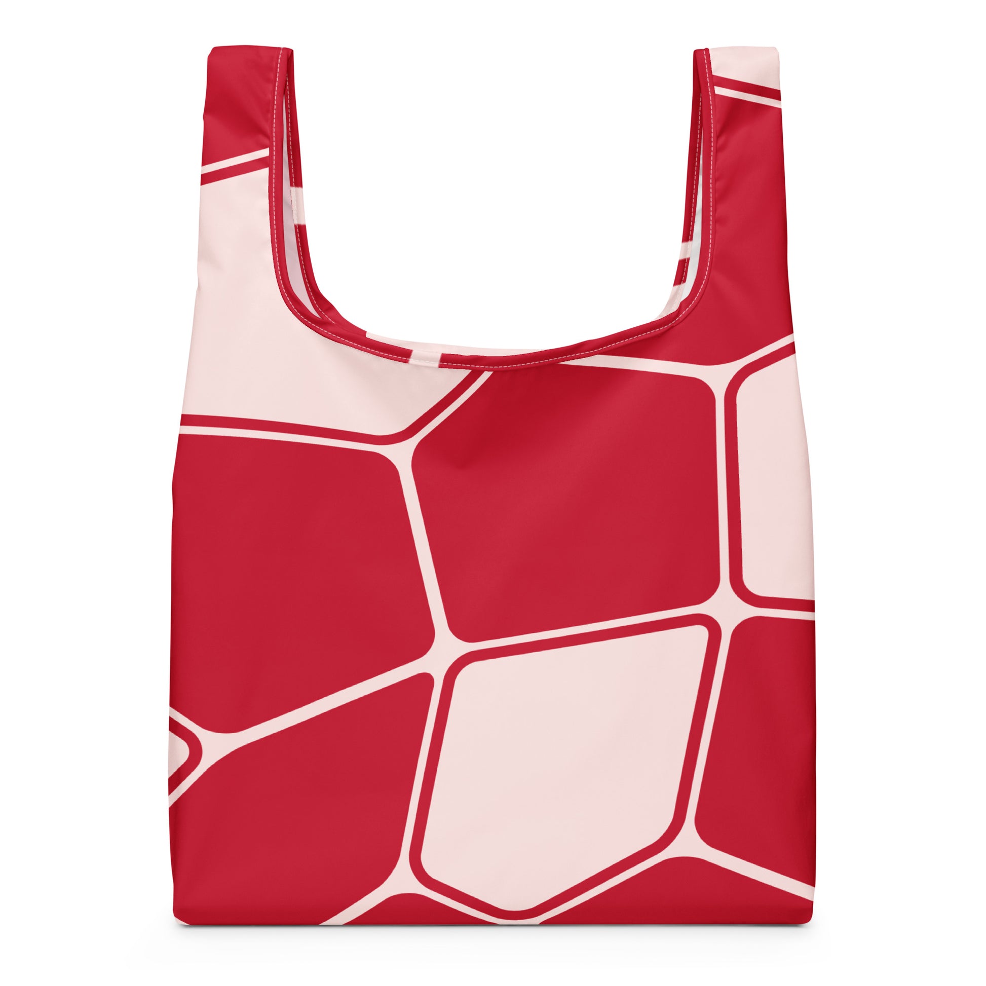 A reusable tote bag with a bold geometric pattern of red and pale pink polygonal shapes outlined in white. 