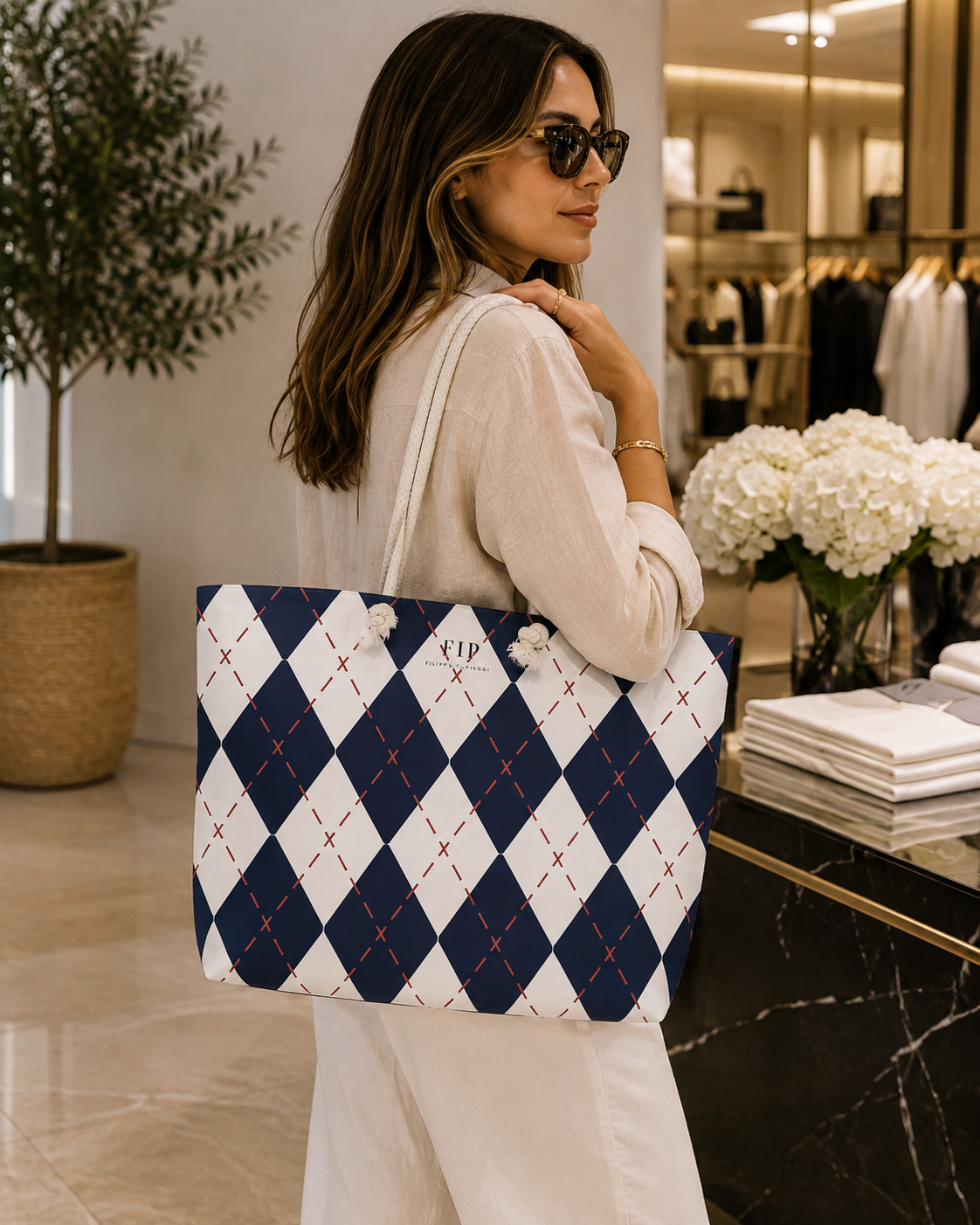 large tote bag with a navy and white argyle pattern featuring small red stitched 