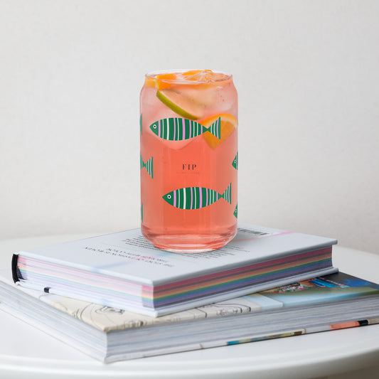 A clear glass can-shaped tumbler  printed with green fish motifs. 
