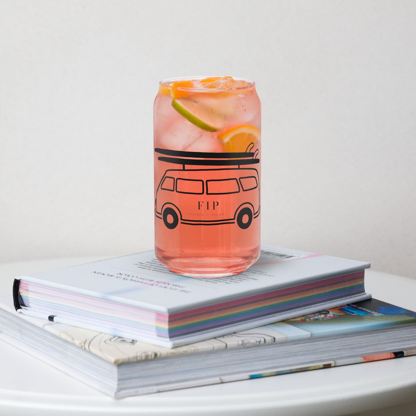A clear glass can-shaped tumbler with a bus. 