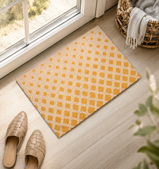 A rectangular doormat with a mustard yellow and beige geometric pattern