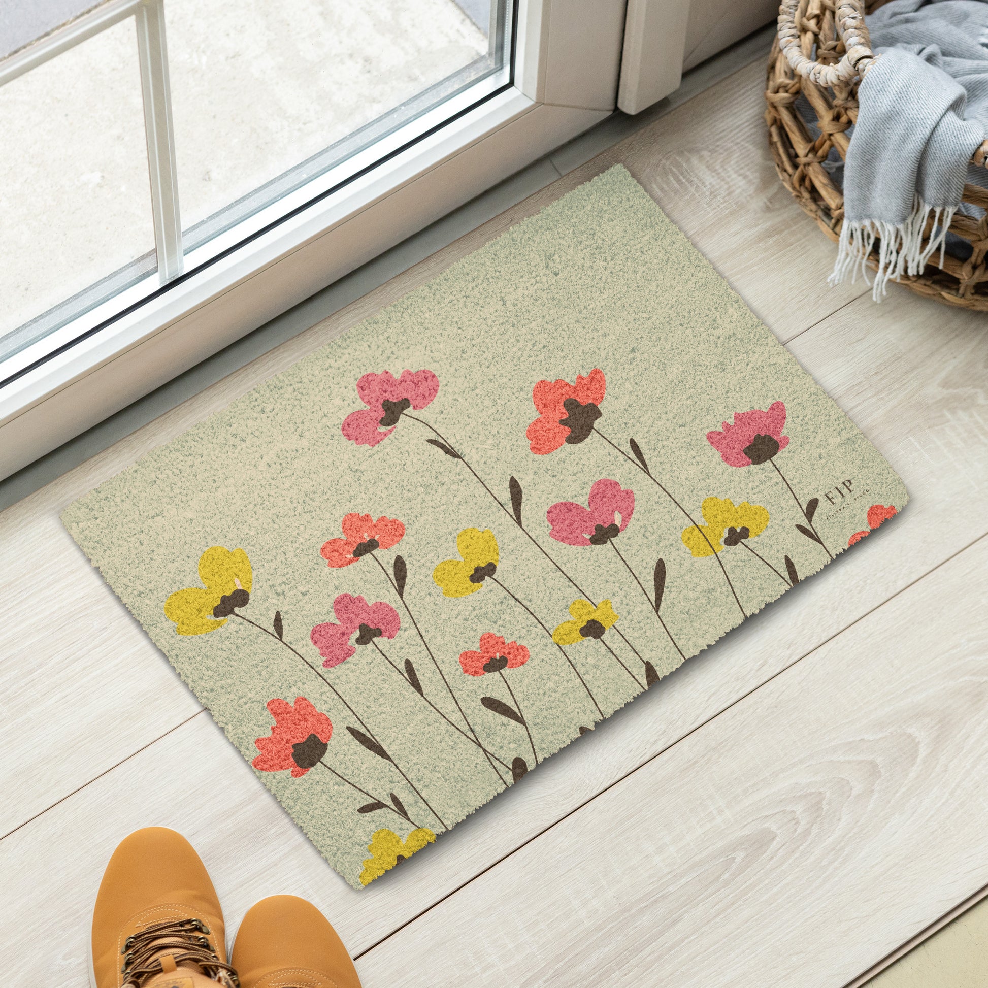 A rectangular doormat with a beige background and a pattern of pink, yellow, and orange flowers with dark brown stems. 