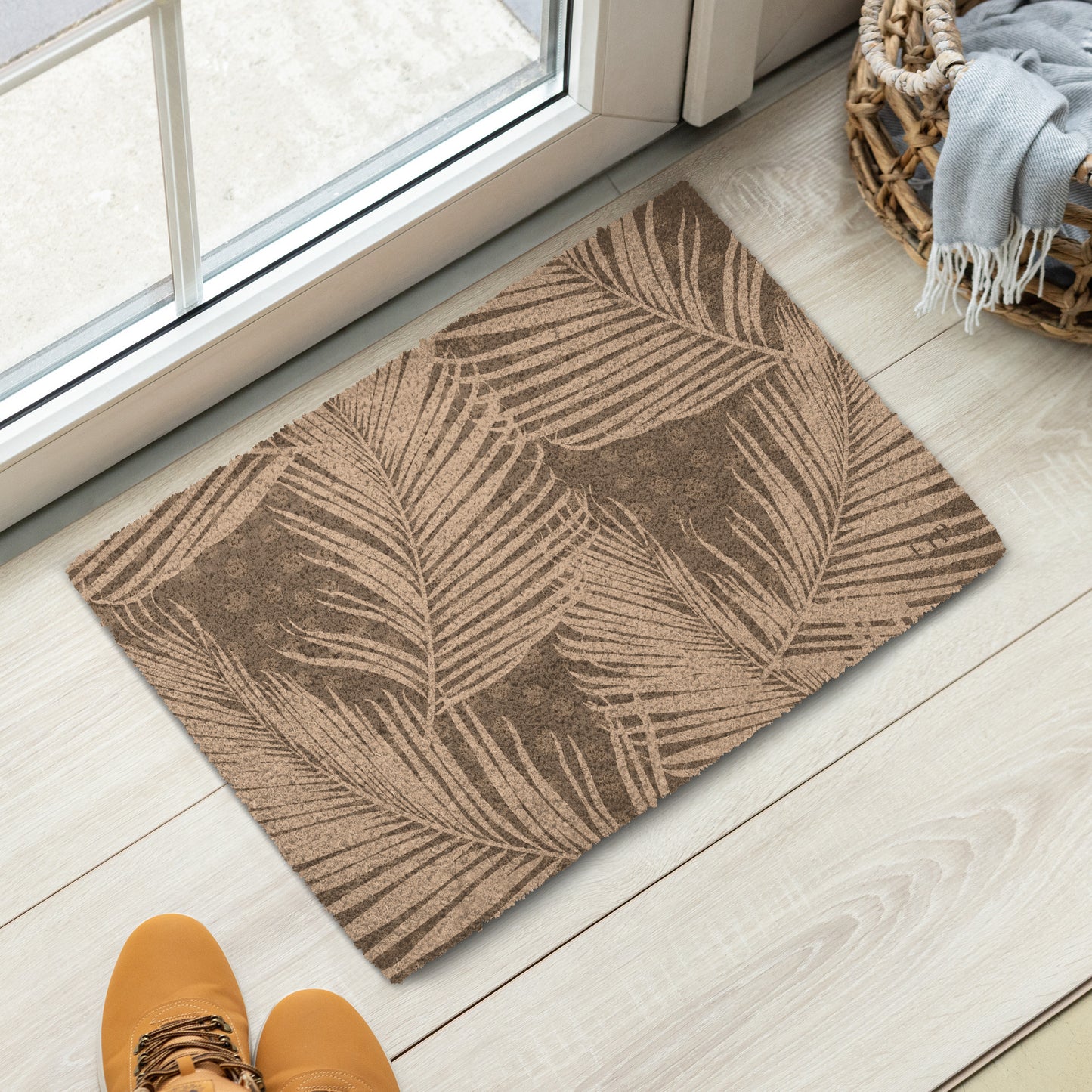 A rectangular entryway mat with a brown and beige palm leaf pattern. 