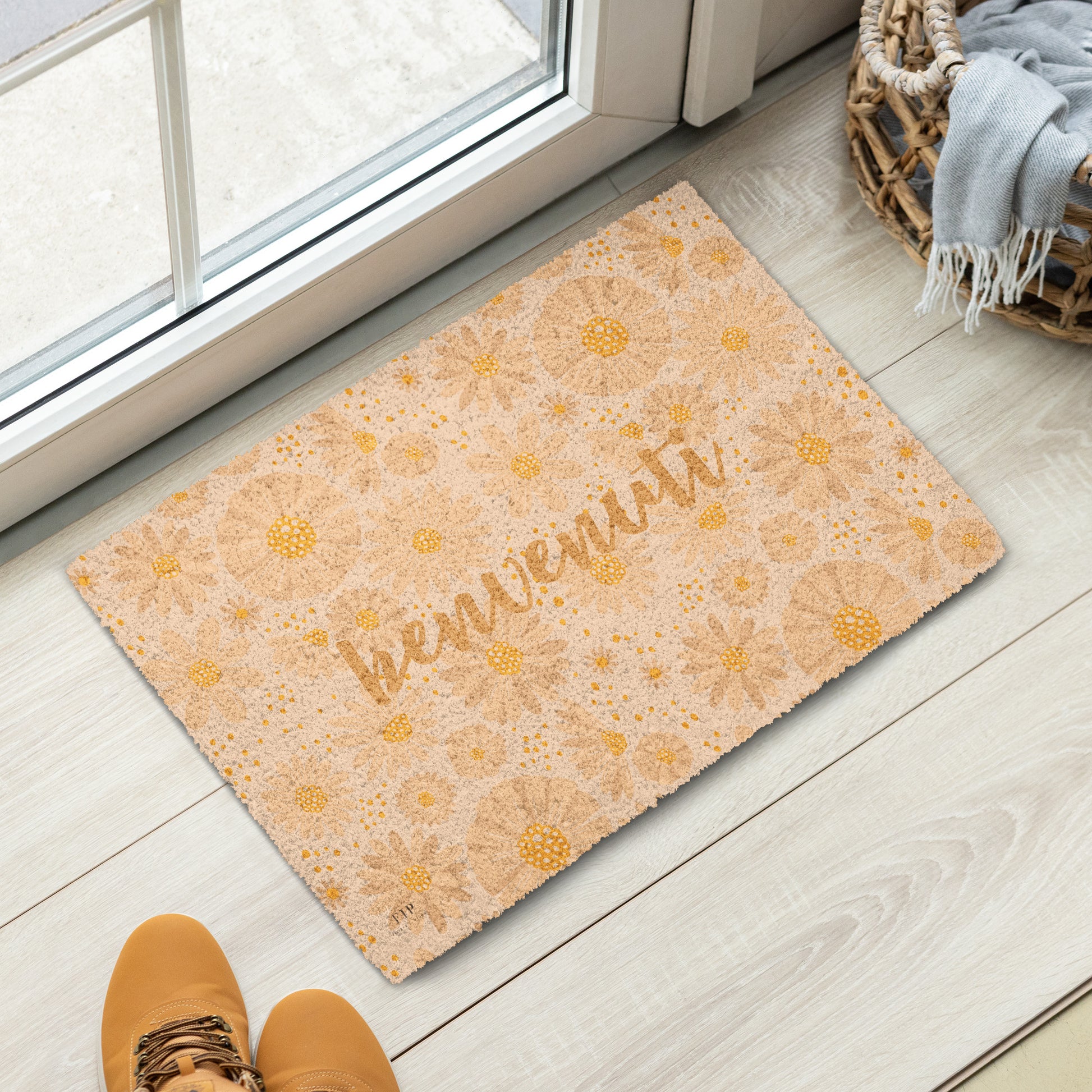 A rectangular doormat with a warm beige and yellow floral pattern and the word 'bienvenuti' in script