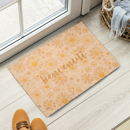 A rectangular doormat with a warm beige and yellow floral pattern and the word 'bienvenuti' in script