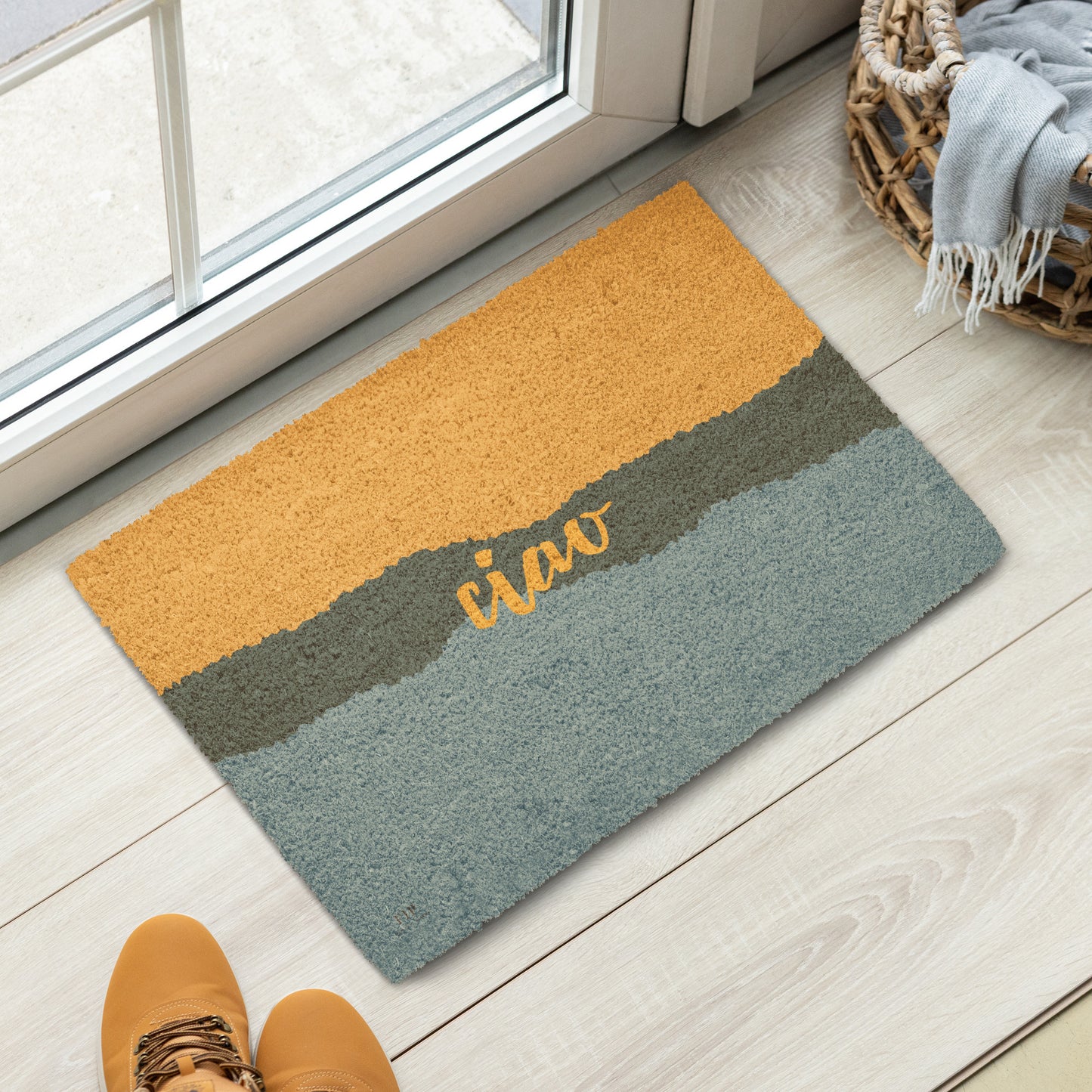 A rectangular coir doormat with a three-stripe color-block design in mustard yellow, dark gray, and slate blue, featuring the word 'ciao' in yellow script. 