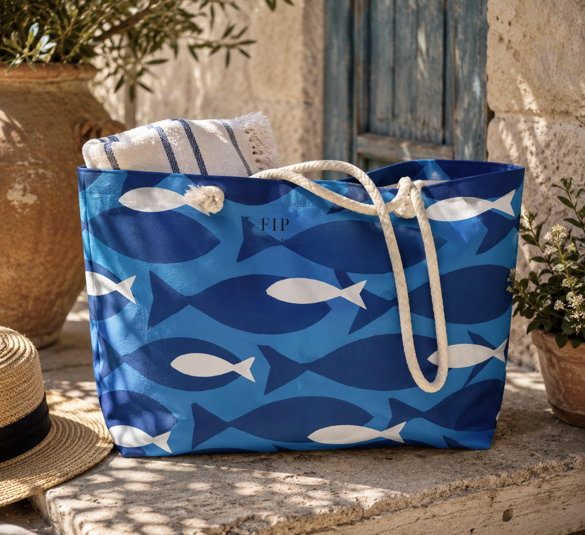 A blue tote bag with a white fish pattern and thick white rope handles