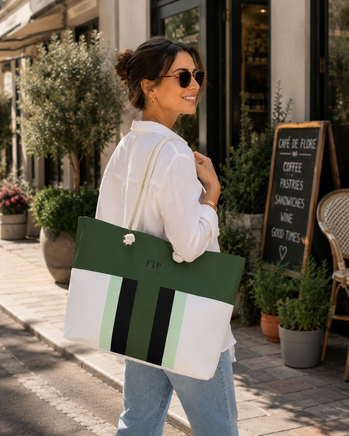  The tote bag has a white base with a wide dark green band and vertical black and pale green stripes.