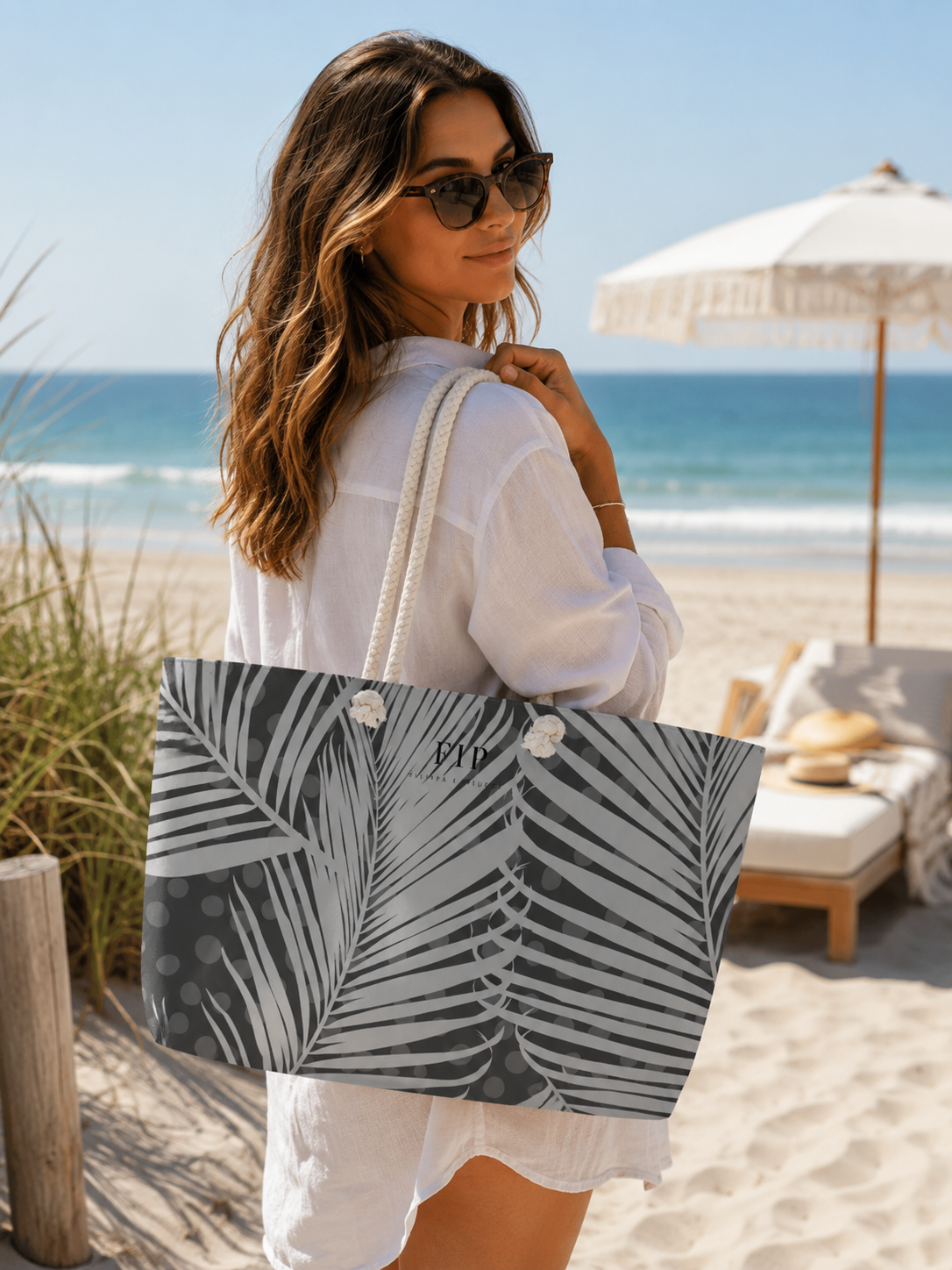 a large tote bag with a gray and white palm leaf pattern. 