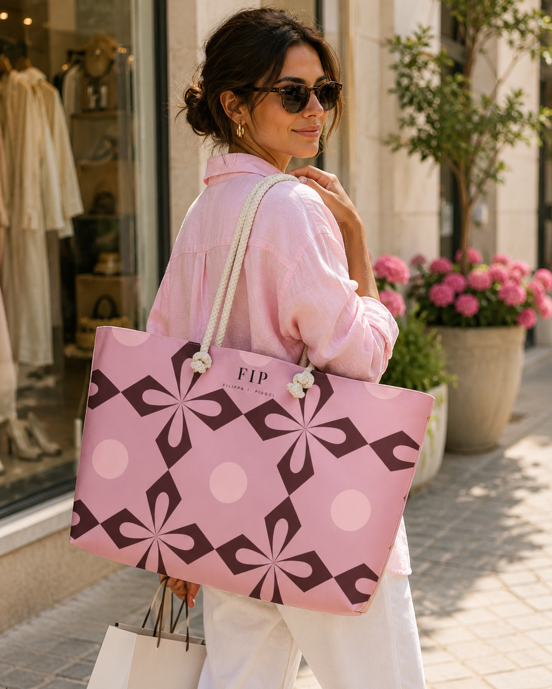 large pink tote bag with a dark geometric pattern and white rope handles
