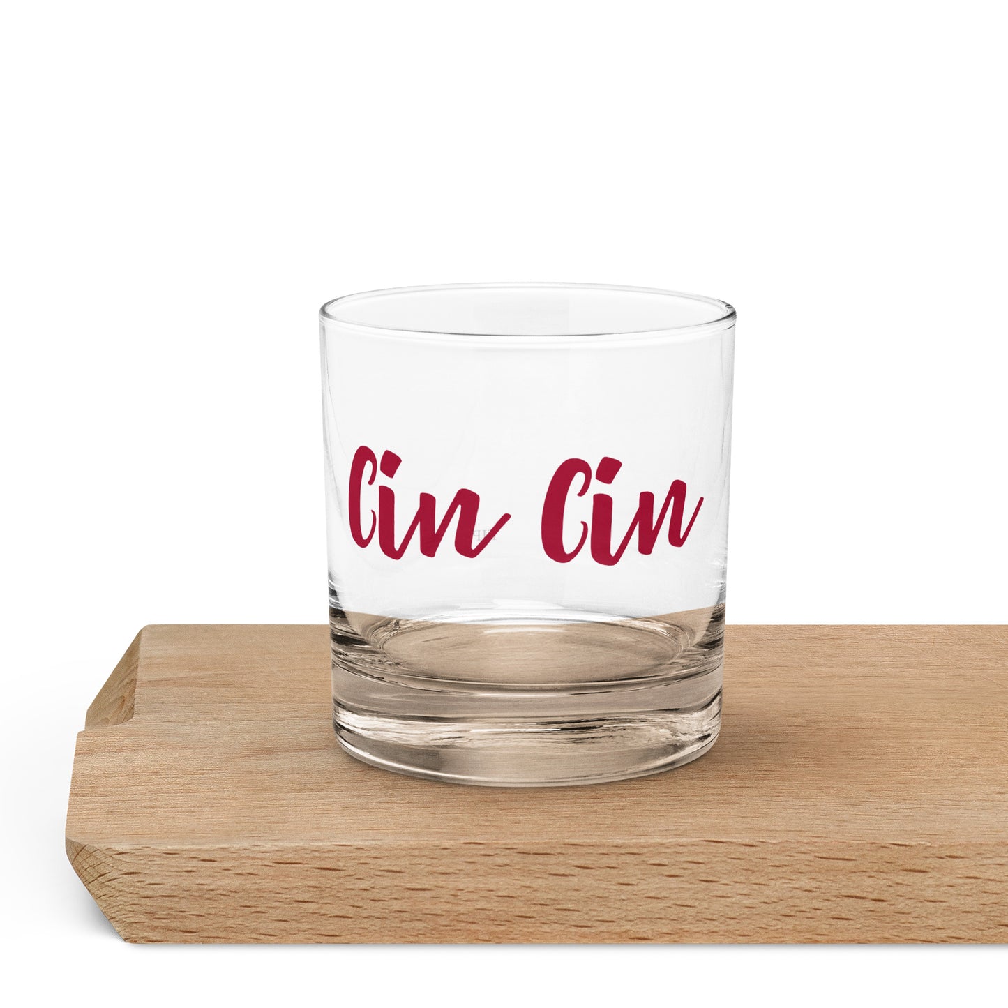 A clear glass rocks tumbler with the words 'Cin Cin' printed in red script. 