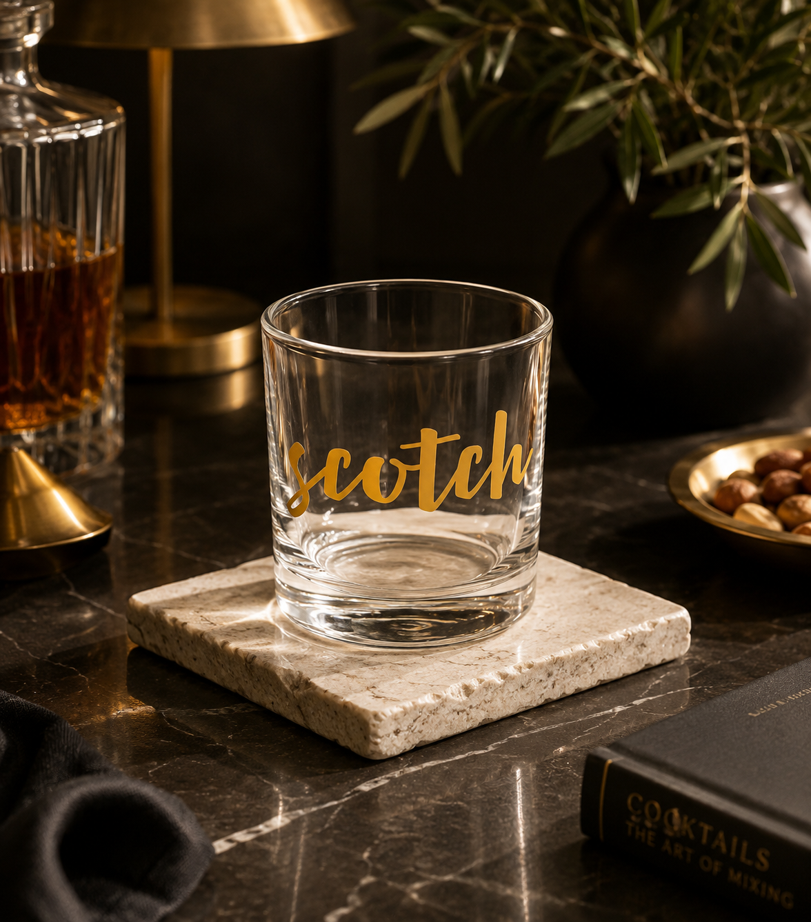 A clear glass rocks tumbler with the word 'scotch' in gold script