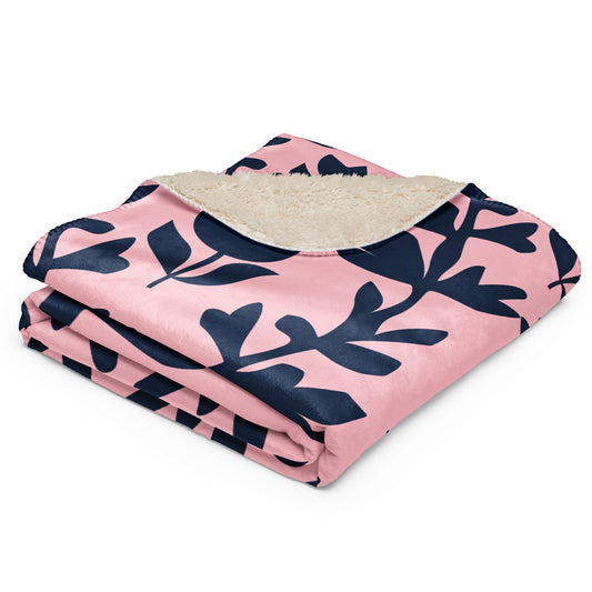 pink sherpa blanket with navy blue leaf pattern.