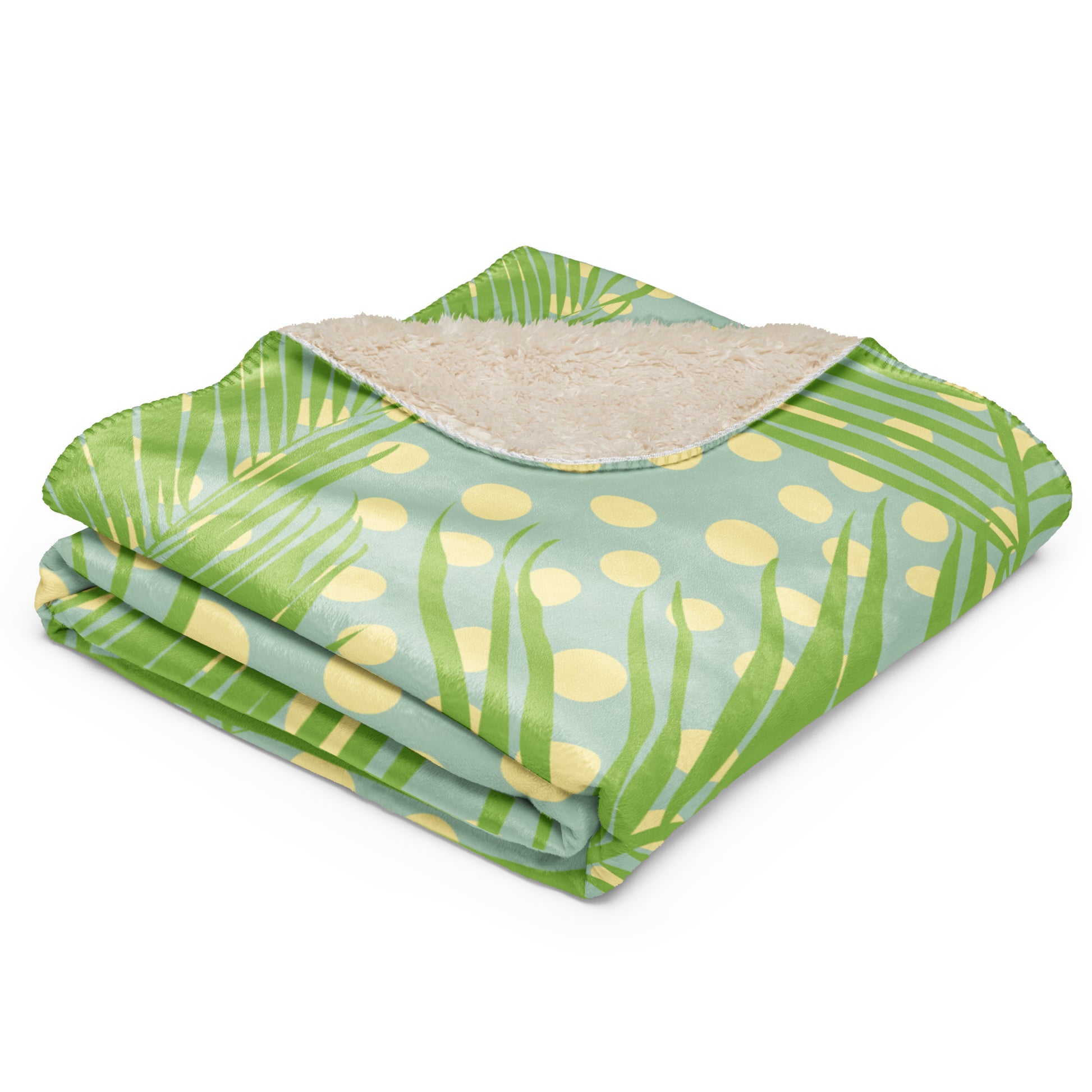 Green tropical palm leaf and polka dot pattern on one side, with a soft beige sherpa lining.