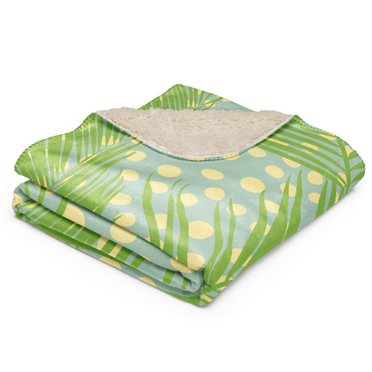 Green tropical palm leaf and polka dot pattern on one side, with a soft beige sherpa lining.