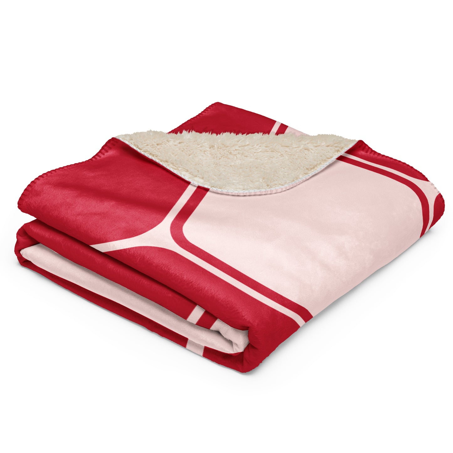  throw blanket with a red and light pink geometric patterned exterior and a cream sherpa fleece lining