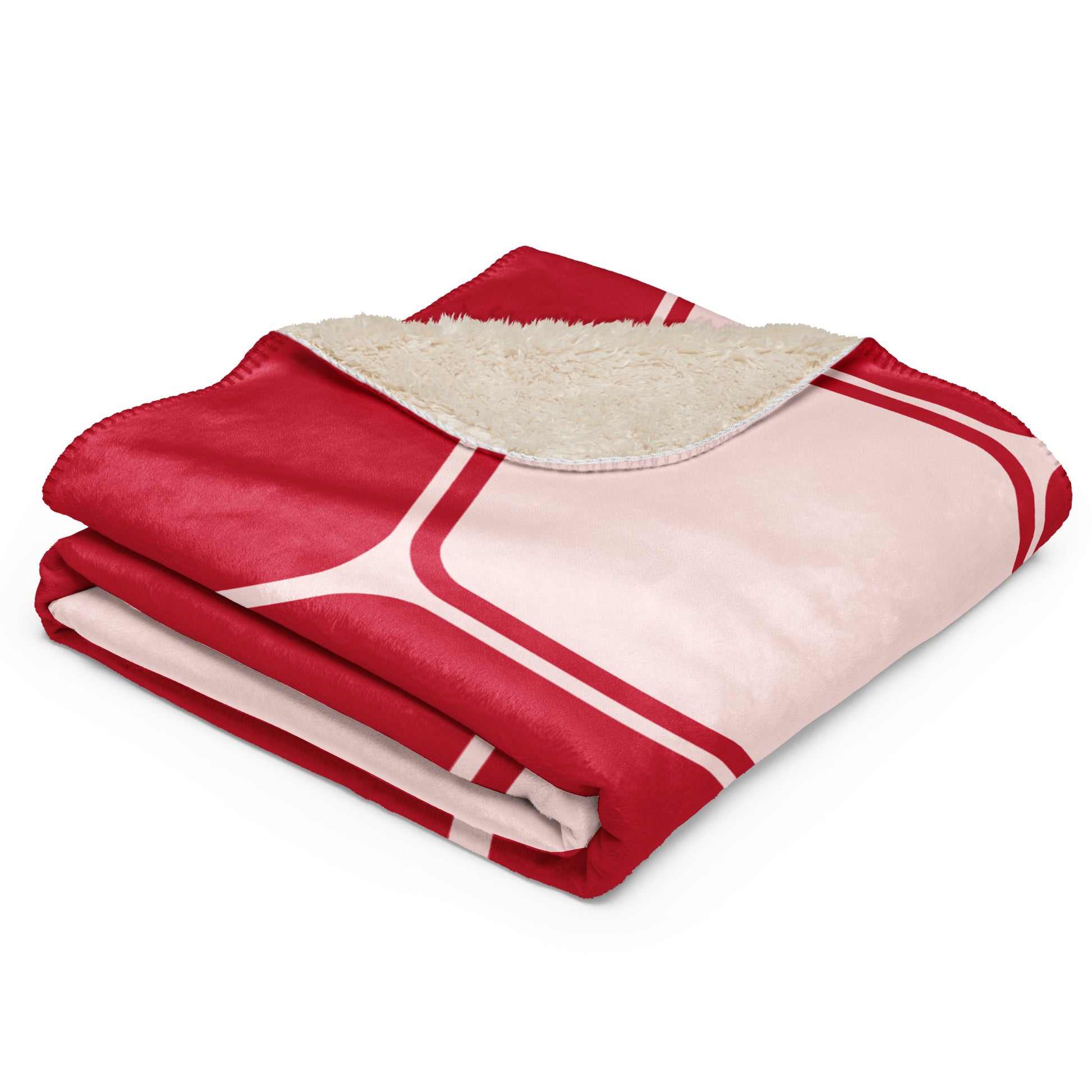  throw blanket with a red and light pink geometric patterned exterior and a cream sherpa fleece lining