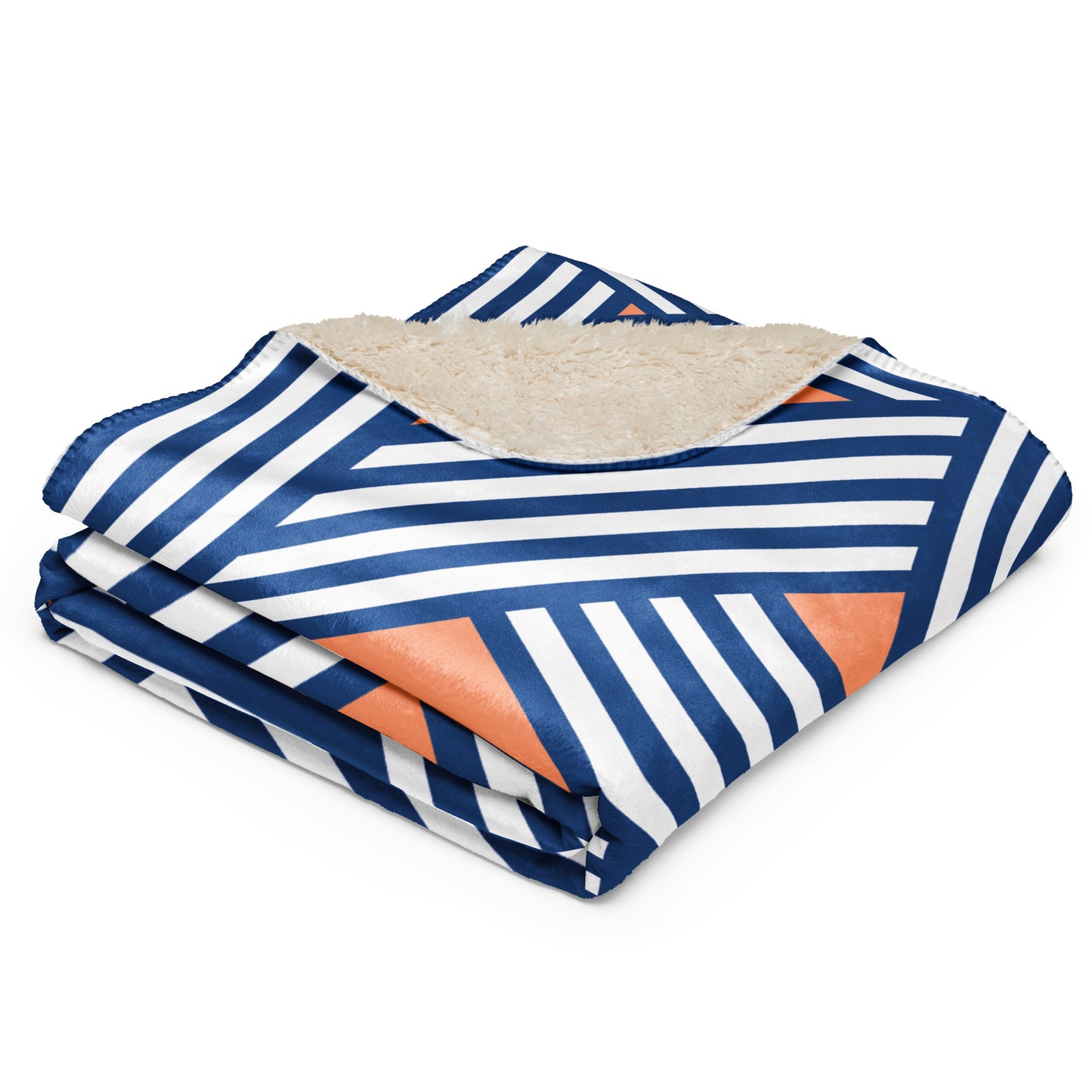 throw blanket featuring a navy blue, white, and orange geometric stripe pattern on one side and a soft beige sherpa lining on the reverse 