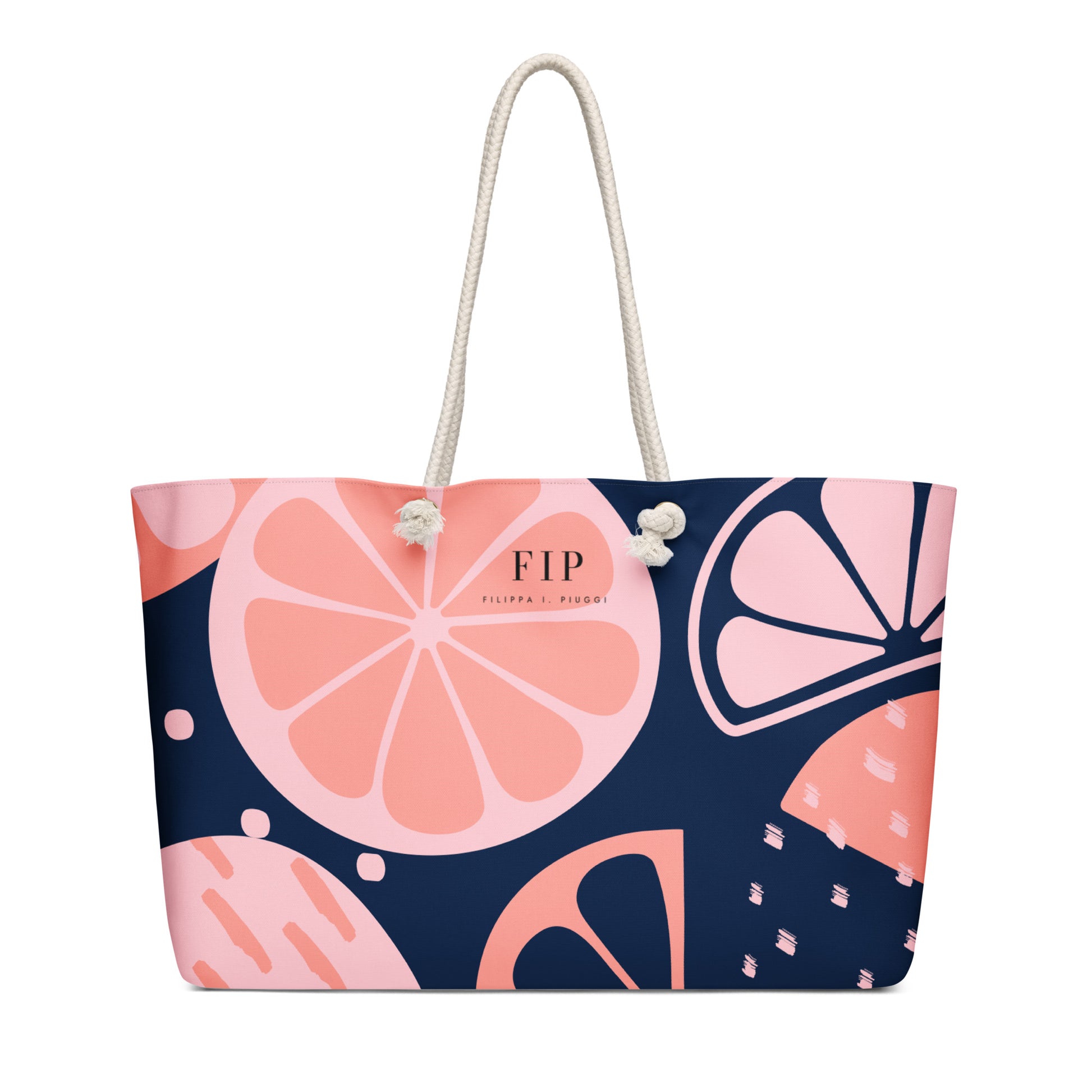 A tote bag with a dark navy blue background and a pink citrus fruit pattern, featuring cream rope handles. 