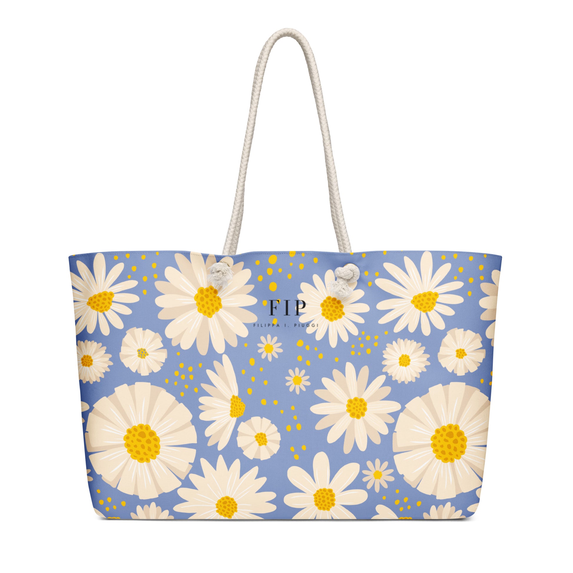 A light blue tote bag with a white and yellow daisy floral pattern, featuring two white rope handles. 