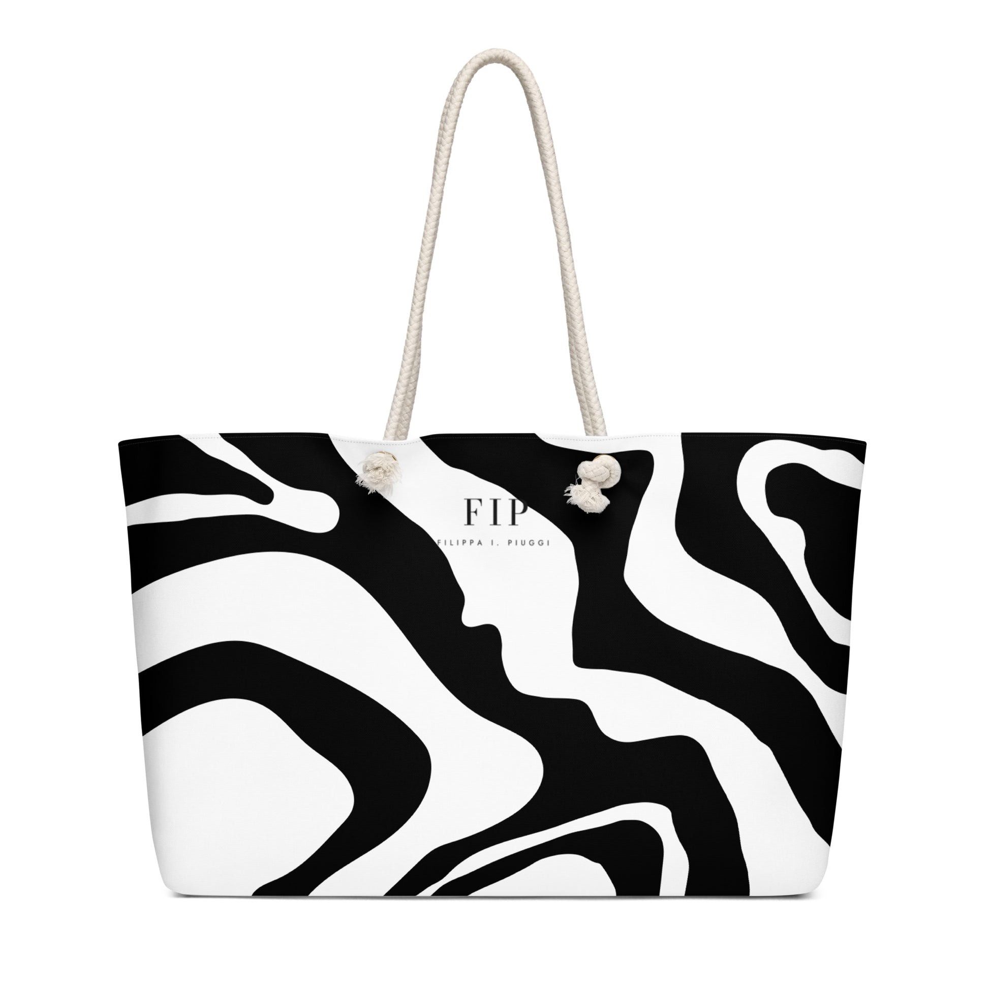 A black and white abstract patterned tote bag with cream-colored rope handles. 