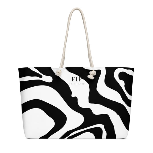 A black and white abstract patterned tote bag with cream-colored rope handles. 