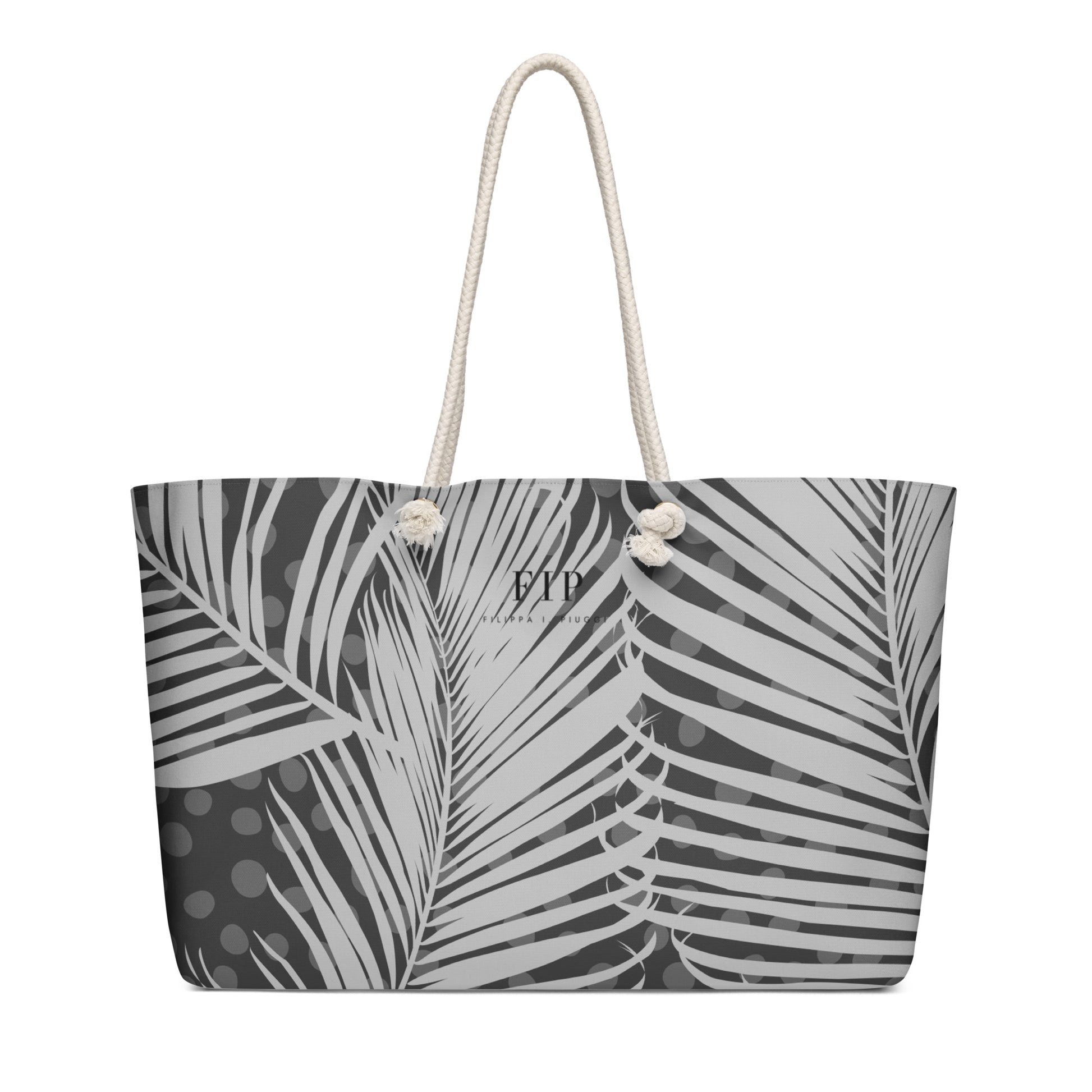 A tote bag featuring a black and white palm leaf pattern, with cream-colored rope handles. 