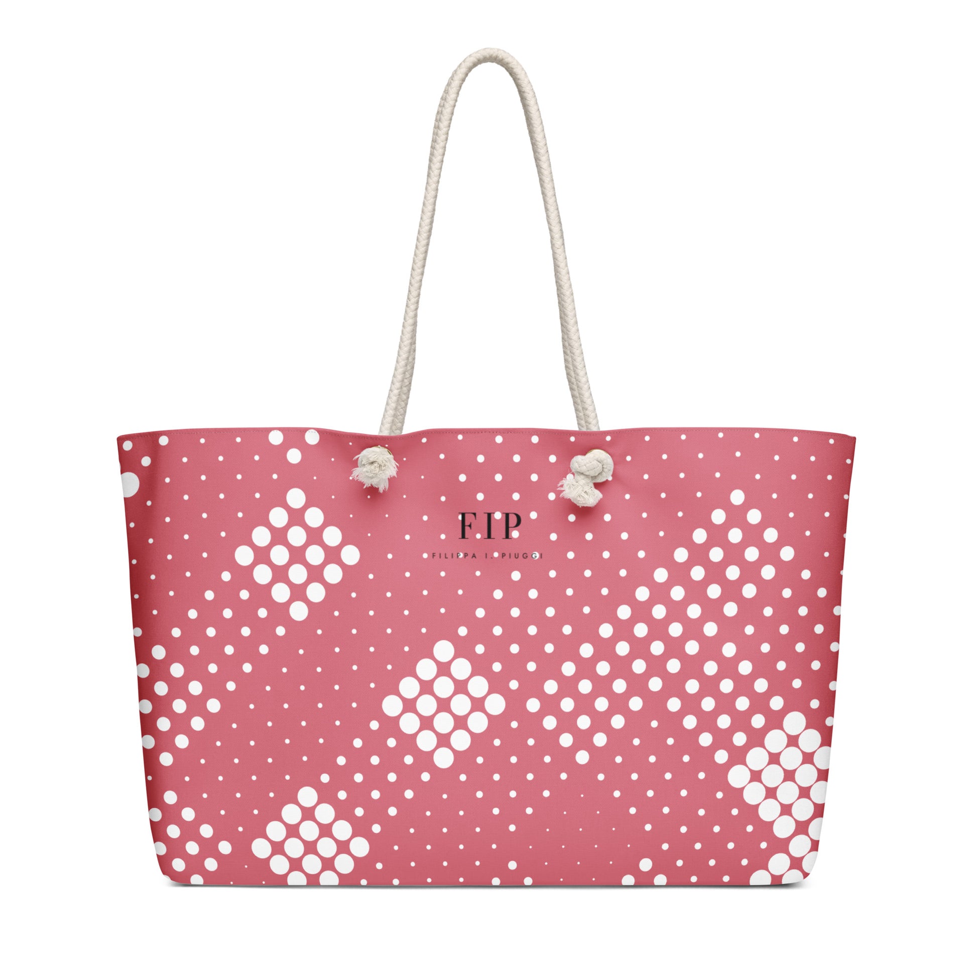 A pink tote bag with a white polka dot and diamond pattern, featuring cream-colored rope handles. 