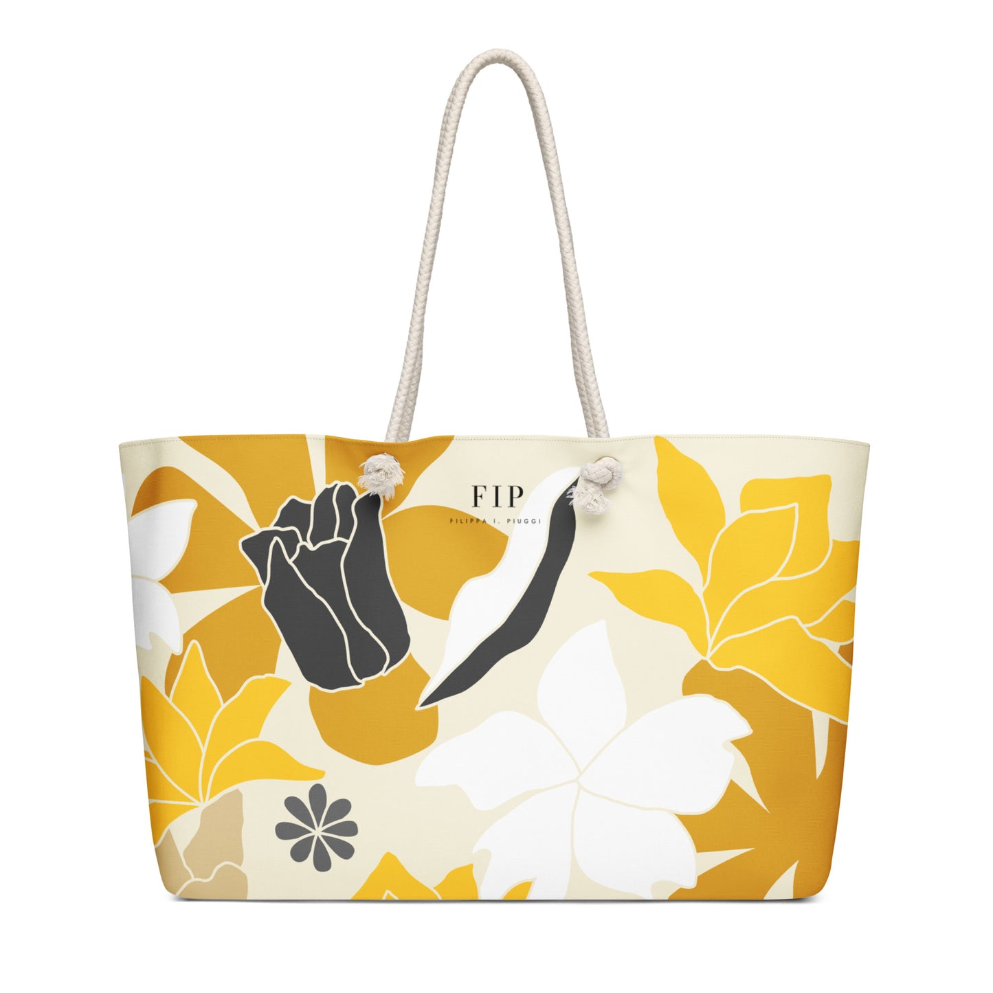 A tote bag with a cream base and a bold yellow, white, and black floral pattern, featuring cream rope handles 