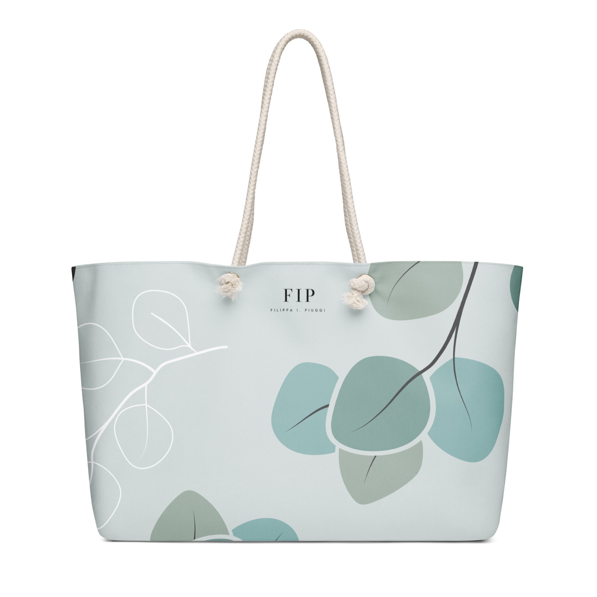 A light blue tote bag with a sage green and teal leaf pattern, featuring cream-colored rope handles 