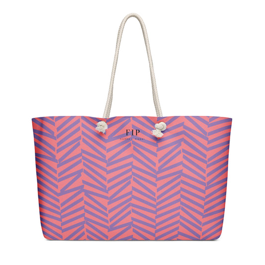 A tote bag with a pink and purple chevron pattern, featuring off-white rope handles 