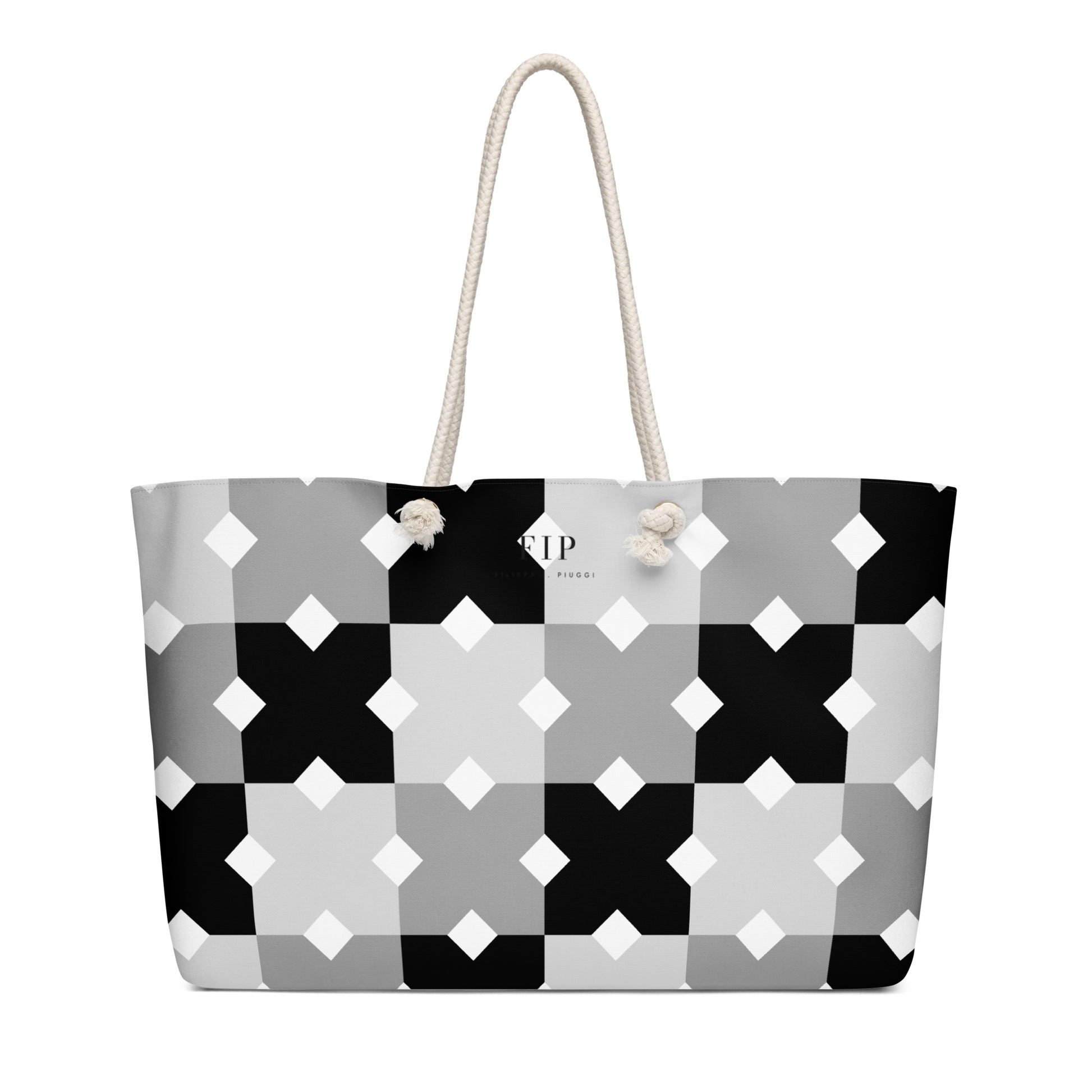A tote bag with a geometric black, gray, and white pattern, featuring cream-colored rope handles 