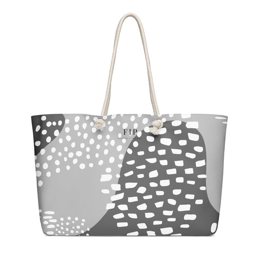 A tote bag with a gray, white, and black organic pattern, featuring cream-colored rope handles