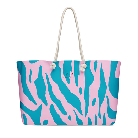 A tote bag with a pink and teal abstract pattern, featuring cream-colored rope handles
