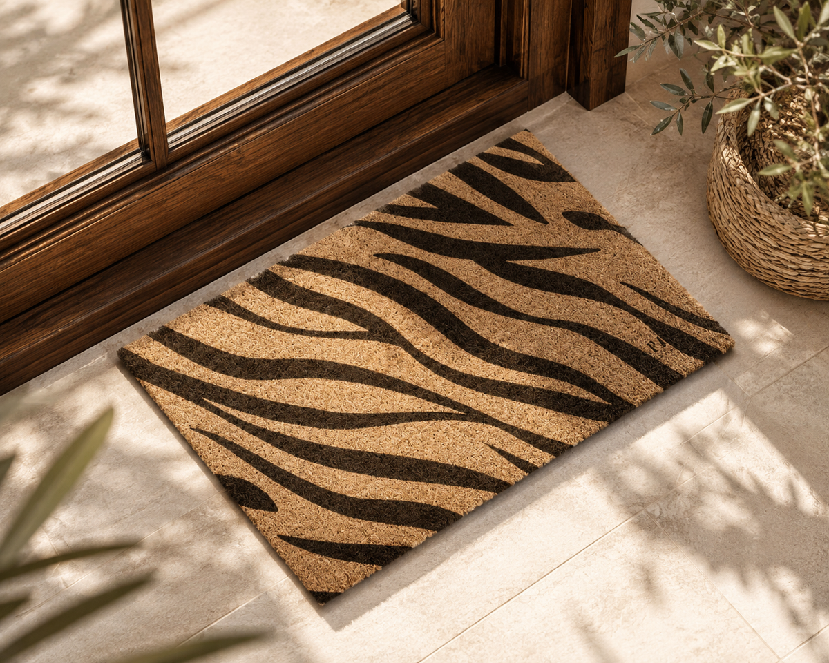 A rectangular natural coir doormat with a bold black zebra stripe pattern,